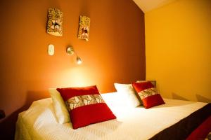 Un dormitorio con una cama con sábanas blancas y almohadas rojas. en Sarapiquí Rainforest Lodge, en Sarapiquí 27 fotos más