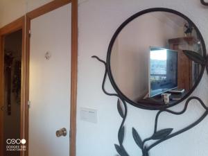 un miroir suspendu sur un mur à côté d'une porte dans l'établissement Coty's Beach, à Benalmádena