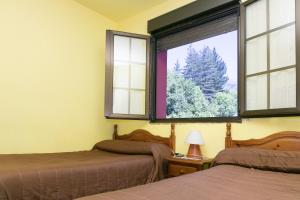 1 dormitorio con 2 camas y ventana en Pensión Casa Cesáreo, en Pola de Somiedo