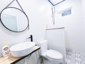 een witte badkamer met een wastafel en een spiegel bij MOre Home - Ngôi nhà nghĩ dưỡng tại Đà Lạt in Da Lat
