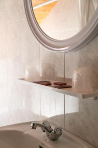 lavabo con espejo encima del lavabo en Pensión Casa Cesáreo, en Pola de Somiedo