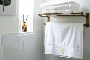 un bagno con asciugamani bianchi su uno scaldasciugamani di Ling Inn a Kaohsiung