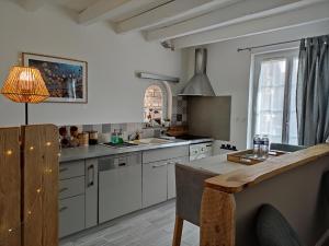 a kitchen with white cabinets and a table with a lamp at Atelier des sens 89 in Évry