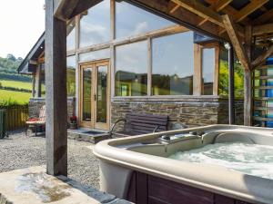 a hot tub in front of a house at Heyope Cottage in Llangunllo