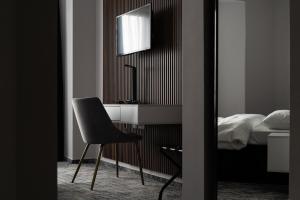 Hotel Cristal في كلوي نابوكا: غرفة نوم مع مكتب وكرسي بجوار سرير