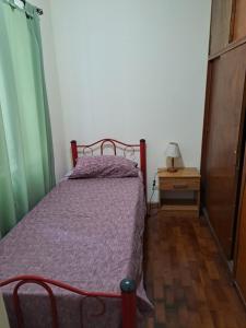 a bedroom with a bed and a table with a lamp at Departamento frente a Plaza España in Mendoza