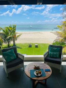 a living room with a view of the beach at Pointe d'Esny Beachfront Luxury Apartment in Pointe d'Esny