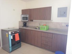 a small kitchen with a stove and a microwave at Edificio Galatea in Manta