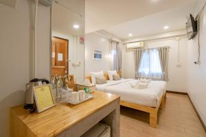 ein Hotelzimmer mit einem Bett und einem Tisch mit Theke in der Unterkunft B House Chiang Mai Thailand in Chiang Mai