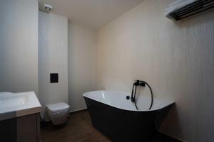 a bathroom with a bath tub and a toilet at Hotel Cristal in Cluj-Napoca