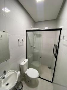 a bathroom with a toilet and a shower and a sink at Hotel Castanhal in Castanhal