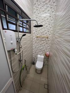 uma casa de banho com um chuveiro e um WC. em Rumah Tamu Zeha Muar Johor em Muar