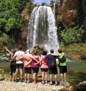 a group of people standing in front of a waterfall at Casa rural la balsa in Anna