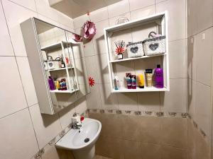 La salle de bains est pourvue d'un lavabo et d'un miroir. dans l'établissement Town Place Apartment, à Kardjali