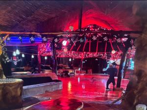 a man standing on a stage with christmas lights at La Perla Negra Eco Pirate Resort in Puntarenas