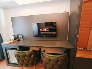 a desk with a tv and two chairs at Kanarya Suite in Istanbul