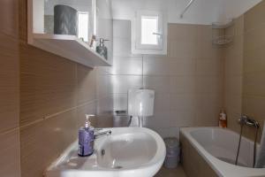 W łazience znajduje się umywalka i wanna. w obiekcie King home Larissa city w mieście Larisa +15 zdjęć