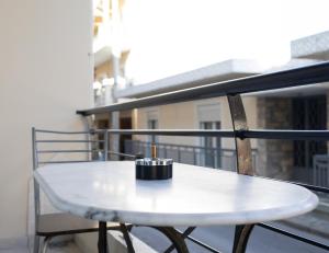 une table blanche sur un balcon avec une bougie dans l'établissement King home Larissa city, à Larissa