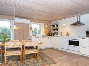 ヴィデ・サンデにあるHoliday home Hvide Sande CXVの木製の天井、白い家電製品付きのキッチン
