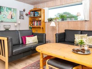 ein Wohnzimmer mit einem Sofa und einem Tisch in der Unterkunft Holiday home Hvide Sande CXV in Hvide Sande