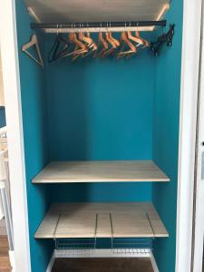 armadio con pareti blu e scaffali in legno di Charmant logement neuf a Hourtin
