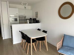 eine Küche mit Tisch und Stühlen in einem Zimmer in der Unterkunft Appartement Wimereux "les pieds dans l'eau", parking, wifi in Wimereux