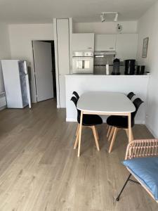 ein Tisch und Stühle in einem Raum mit Küche in der Unterkunft Appartement Wimereux "les pieds dans l'eau", parking, wifi in Wimereux + 12 Fotos