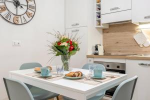 a white dining room table with a vase of flowers at Donna Teresa Central & Cozy Apartment in Taranto +8 photos