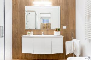 y baño con lavabo blanco y espejo. en Donna Teresa Central & Cozy Apartment, en Taranto