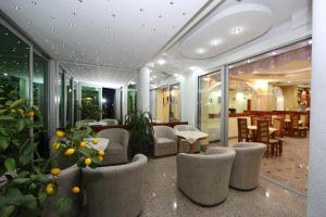 hol hotelowy z krzesłami, stołami i oknami w obiekcie Villa Maki w Ochrydzie
