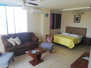 a living room with a couch and a bed at Edificio Galatea in Manta
