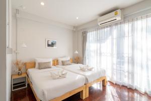 a bedroom with two beds and a large window at B House Chiang Mai Thailand in Chiang Mai