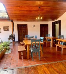皮塔利托Hotel Colonial Andino - Parque principal de Pitalito的一个带木桌椅和天花板的庭院