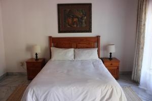 a bedroom with a white bed with two night stands at El Palmar Guesthouse in Groblersdal +38 photos
