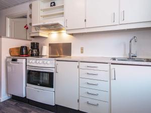 a kitchen with white cabinets and a white stove top oven at 6 person holiday home in Lemvig in Lemvig