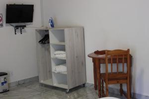 a room with a wooden cabinet and a table and a television at El Palmar Guesthouse in Groblersdal