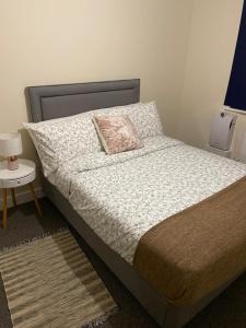 a bedroom with a bed with a pillow and a table at David’s apartment in London