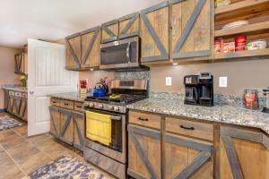 a kitchen with wooden cabinets and a stove top oven at Rio House Retreat in Tazewell