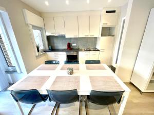 a kitchen with a large white table and chairs at Duinenblik 5 in Nieuwpoort +18 photos