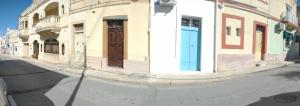 una strada con un edificio con porte di Cozy room a Birżebbuġa