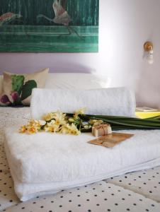 a white towel with flowers on a bed at Ferula loft in Sortino