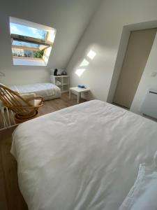 Un dormitorio con una gran cama blanca y una ventana en Chambre chez Marjorie, en Brest