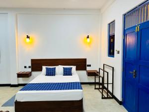 a bedroom with a large bed with blue doors at Sundaze Villa in Goyambokka