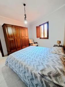カステル・ディ・サングロにあるCasa Vacanze La Civitaのベッドルーム1室(大型ベッド1台、木製キャビネット付)