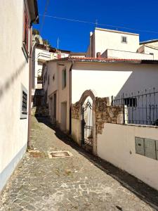 un callejón con un edificio blanco y una puerta en Casa Vacanze La Civita, en Castel di Sangro