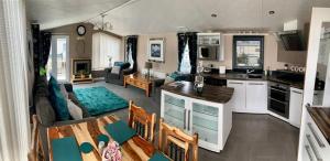 a kitchen and a living room with a couch and a table at Luxury Caravan - WI-FI and SMART TV newly installed in Rhyl