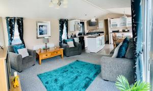 uma sala de estar com dois sofás e uma cozinha em Luxury Caravan - WI-FI and SMART TV newly installed em Rhyl