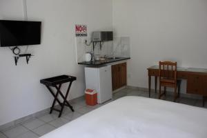 Zimmer mit einer Küche, einem Schreibtisch und einem TV in der Unterkunft El Palmar Guesthouse in Groblersdal
