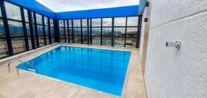 a swimming pool with a view of a building at Hotel Portal dos Devotos in Aparecida