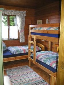 two bunk beds in a log cabin with a window at Ferienhaus in Wolfsberg mit Offenem Kamin und Panoramablick in Klippitztorl